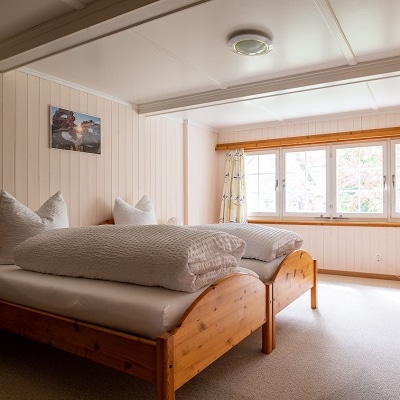 Schlafzimmer mit Holzausstattung und gemütlichen Betten, ideal für Erholung, Selbstfürsorge und Selbstliebe.